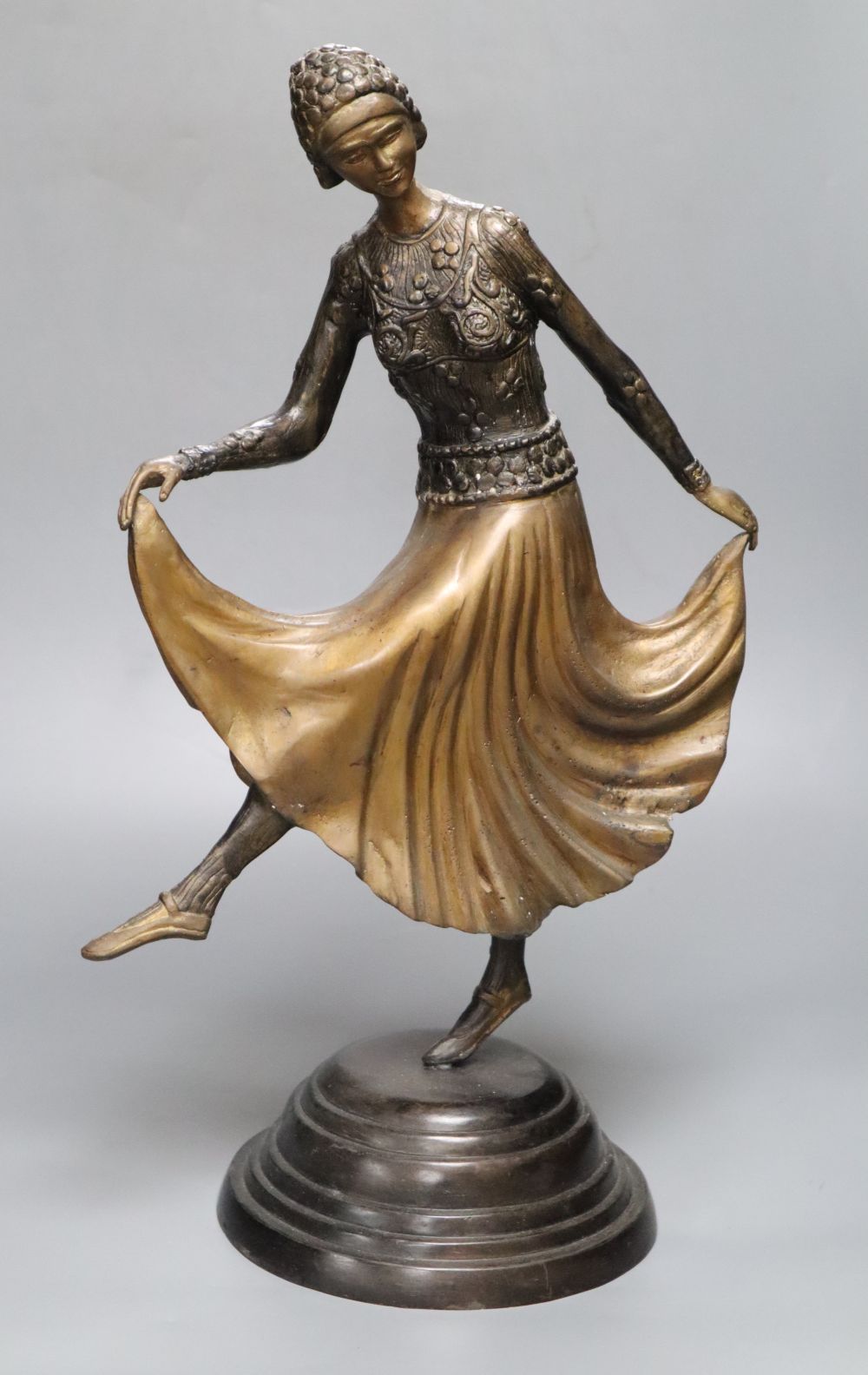 A patinated metal model of a 1930s dancer, on stepped circular base, 48cm